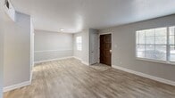 Located at 6100 Waters Ave in Savannah, Georgia, this single-floor, 2-bedroom, 1-bathroom home offers a thoughtfully arranged layout with a range of updated finishes throughout. The entry opens into a bright living area featuring light wood-look flooring, neutral gray walls, and a classic textured ceiling. A standout feature of the home is the striking exposed brick accent wall, which adds warmth and character to the living space. Adjacent hallways connect the rooms seamlessly, creating an efficient and cohesive flow. The kitchen is well-equipped with white shaker cabinetry, granite-look countertops, stainless steel appliances including a refrigerator, range, microwave, and dishwasher, and light tile flooring. Both bedrooms are carpeted and feature ceiling fans with light fixtures. The primary bedroom is generously sized and includes closet access, while the second bedroom offers a closet with louvered doors and a window with natural light. A sliding glass door in one of the carpeted rooms allows access to the outdoors. The full bathroom includes a tiled tub-and-shower combination, wood-look tile flooring, and a vanity with granite-style countertops. A utility room and two hallways complete the layout.