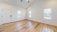Located at 4520 Guadalupe Church St NW in Albuquerque, this thoughtfully designed one-bedroom, one-bathroom unit offers a clean, contemporary aesthetic across a single floor. Warm wood-look flooring flows seamlessly throughout every room, tying the space together with a cohesive, modern feel.

The open-concept kitchen and living area serves as the heart of the unit. The kitchen is well-appointed with light gray shaker-style cabinetry featuring matte black hardware, white quartz countertops, a farmhouse sink, white subway tile backsplash, and a full suite of stainless steel appliances including a slide-in range, over-the-range microwave, dishwasher, and a large side-by-side refrigerator. A pendant light adds a stylish accent above the workspace.

The living area benefits from vaulted ceilings and multiple windows that invite an abundance of natural light, creating an airy and open atmosphere. A ceiling fan provides added comfort.

The bedroom is a well-proportioned, bright retreat with a window overlooking the outdoors and direct access to a dedicated closet. The full bathroom is finished to a high standard, showcasing a dual-sink vanity with sage-toned cabinetry, a frameless glass walk-in shower with white square tile, a built-in niche, and matte black fixtures throughout. Built-in shelving provides convenient storage.