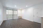 Located at 20700 El Toro Rd in Lake Forest, CA, this single-floor unit offers a clean, modern aesthetic with thoughtful updates throughout. The open-concept layout connects the living area to the kitchen seamlessly, with light wood-style flooring running consistently across the space, contributing to a bright and cohesive feel.

The kitchen is well-appointed with white shaker-style cabinetry, light quartz countertops, a stainless steel sink, and stainless steel appliances including a range and microwave. Recessed lighting illuminates a tray ceiling above, and a dedicated pantry provides generous storage. A peninsula with a built-in sink extends into the living area, enhancing functionality and flow.

The bedrooms are comfortably sized, each featuring ceiling fans with light fixtures and the same wood-style flooring. One bedroom includes access to a walk-in closet with built-in shelving and cabinetry. A second bedroom benefits from a window with vertical blinds, allowing natural light to filter in.

The bathroom is finished with a white vanity, quartz countertop, a large mirror, and a full tub-shower combination. Clean white walls and recessed lighting give the space a crisp, refreshed appearance throughout. The overall interior presents a move-in ready, well-maintained environment suited for comfortable everyday living.