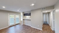 Located in Lewisville, TX, this 2-bedroom, 2-bathroom single-floor residence offers a functional and well-appointed layout. The living room features warm wood-look flooring, recessed lighting, and French doors that invite natural light and outdoor views. Adjacent to the living area, the dining room is highlighted by a stylish chandelier and large windows with outdoor views, creating a bright and welcoming space. The galley-style kitchen is efficiently designed with dark cabinetry, marble-look countertops, a stainless steel sink, and white appliances including a range, dishwasher, and refrigerator. Both bedrooms are comfortably carpeted and include ceiling fans and windows that bring in natural light. The primary bedroom offers generous proportions along with closet access. The bathrooms are finished with updated dark vanities, marble-look countertops, and clean white tub-shower combinations complemented by wood-look flooring. A dedicated closet adds convenient storage. Neutral gray tones throughout the home create a cohesive, modern aesthetic, while white six-panel doors and crisp baseboards contribute a clean, finished look across every room.