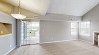 Located at 3800 Meriwether Dr in Durham, NC, this single-floor, 2-bedroom, 2-bathroom home offers a well-organized layout with comfortable living spaces throughout. The living room is a standout area, featuring soaring vaulted ceilings that create an airy, open atmosphere, soft carpeted flooring, and large windows alongside a sliding glass door that invite abundant natural light and outdoor views. The kitchen is appointed with rich dark wood cabinetry, light countertops, a double-basin sink, and wood-look flooring, providing a functional and cohesive cooking space. The primary bedroom continues the vaulted ceiling design, offering generous proportions, plush carpet, and direct access to a private en-suite bathroom equipped with a walk-in shower. The second bedroom also benefits from vaulted ceilings, a large window with natural light, and carpeted flooring, served by a second bathroom featuring a shower-tub combination. Both bathrooms include vanities with mirrors and light countertops. A dedicated laundry room with a full-size washer and dryer, dark upper cabinetry, and wood-look flooring adds everyday convenience. Two closets provide ample storage throughout the home.