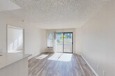 Located on El Cajon Boulevard in San Diego, CA, this single-floor, 3-bedroom, 2-bathroom home offers a well-organized and functional layout. The open-concept living, dining, and kitchen area serves as the heart of the home, bathed in natural light through large windows and a sliding glass door that opens to outdoor views of lush greenery. The living area features smooth wood-look flooring and a textured ceiling, creating a bright and welcoming atmosphere.

The kitchen is thoughtfully designed with white shaker-style cabinetry reaching toward the ceiling for ample storage, a peninsula with a double-basin sink, white appliances, and wood-look flooring that ties the space together seamlessly.

Each of the three bedrooms is carpeted for comfort and features closet storage, with the primary bedroom offering an en-suite bathroom and a dedicated walk-in closet. The secondary bedrooms are well-lit with large windows and sliding closet doors. Both bathrooms include tub-shower combos and clean white finishes, with one featuring white cabinetry and warm wood-look flooring. With four closets distributed throughout, storage is plentiful. The neutral palette and consistent finishes throughout the home create a cohesive and move-in-ready living environment.