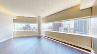 Located in the heart of downtown Dallas on N Saint Paul Street, this high-rise residence offers two bedrooms, three bathrooms, and a thoughtfully designed single-level floor plan. The open-concept living and kitchen area is anchored by rich hardwood flooring and a tray ceiling with integrated ambient lighting, creating a warm yet contemporary atmosphere. The kitchen is a standout feature, showcasing dark espresso cabinetry, stainless steel appliances including a French door refrigerator, a flat-top range, and built-in microwave, complemented by a white quartz countertop island with pendant lighting and a classic subway tile backsplash. The bedrooms are carpeted for comfort and distinguished by elegant cylindrical columns and large windows that frame dramatic views of the Dallas skyline, filling each room with natural light. Ceiling fans add a practical touch. The bathrooms are finished with large-format tile flooring, dark navy vanity cabinetry, white quartz countertops, and glass-enclosed walk-in showers. The closets feature adjustable wood shelving and hanging systems, while the dedicated laundry room includes a full-size washer and dryer. This residence combines urban sophistication with functional living in one of Dallas's most vibrant neighborhoods.