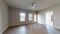 This single-story residence offers a thoughtfully designed layout that balances open communal spaces with comfortable private quarters. The living area features light wood-look flooring, neutral-toned walls, and ceiling fans, with multiple windows fitted with horizontal blinds that invite natural light throughout the day. A door provides direct exterior access, adding convenience to the living space.

The kitchen is well-equipped with white shaker-style cabinetry, a subway tile backsplash, stainless steel appliances including a range, microwave, refrigerator, and dishwasher, and a central island with pendant lighting overhead. An adjacent built-in nook with open shelving and seating adds a functional organizational touch near the entry.

The bedrooms are carpeted for comfort and include ceiling fans and windows that allow natural light. At least one bedroom features access to a walk-in closet. The bathrooms are finished with crisp white subway tile, including a soaking tub with a tiled surround and a separate glass-enclosed walk-in shower with chrome fixtures and wood-look tile flooring, creating a clean, modern aesthetic throughout.