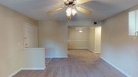 This one-bedroom, one-bathroom residence at The Palladian is designed as a straightforward single-floor layout that maximizes functionality throughout. The living area features warm neutral tones, plush carpeting, and a ceiling fan with integrated lighting, creating a comfortable and well-ventilated environment. A half-wall partition defines the entry area, transitioning seamlessly into the main living space, which opens further into a secondary area illuminated by a pendant light—ideal for use as a dining or flex space.

The bedroom is generously proportioned, offering plush carpeting, a ceiling fan, and a sliding glass door that leads to a private balcony with outdoor views. A walk-in closet provides ample storage directly off the bedroom.

The kitchen is laid out in a galley style, featuring warm wood-toned cabinetry, granite-look countertops, a double-basin sink, and white appliances including a refrigerator, electric range, and dishwasher. Hardwood-style flooring runs throughout the kitchen, adding a practical and clean aesthetic.

The bathroom includes a tub-shower combination, a toilet, and a vanity with granite-look countertops, complemented by hardwood-style flooring. The textured ceilings throughout the unit add a classic residential character to the overall space.