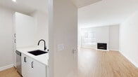 Located in the vibrant Los Feliz neighborhood of Los Angeles, this thoughtfully updated single-floor residence offers a clean, modern aesthetic throughout. Light wood flooring flows seamlessly across every room, complemented by crisp white walls and abundant natural light.

The open-concept living area is anchored by a classic fireplace framed by large windows fitted with blinds, creating a warm yet bright gathering space. Adjacent to the living area, the kitchen features white shaker cabinetry, a subway tile backsplash, stainless steel appliances including a refrigerator, range, and microwave, and a peninsula with a sleek white quartz countertop and matte black undermount sink — ideal for both cooking and casual dining.

The bedrooms are generously proportioned, each bathed in natural light through sizable windows. One bedroom offers sliding door access, adding to the airy feel of the space.

Two bathrooms serve the residence. One is a full bath featuring a tiled shower-tub combination, white vanity with quartz countertop, and black hardware accents. The second is a well-appointed half or three-quarter bath with a wide vanity, large mirror, and matching black cabinet hardware, maintaining the home's cohesive modern design throughout.