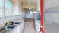 Located at 1132 Phoenix Ave in Seaside, California, this single-story, one-bedroom, one-bathroom home offers a thoughtfully efficient layout. A defining architectural feature throughout the home is the white-painted wood plank ceiling with exposed beams, lending a clean, cottage-like character to the interior.

The living room is carpeted and open, connecting seamlessly to the galley-style kitchen. The kitchen is outfitted with white cabinetry, light countertops, tile flooring, a stainless steel refrigerator, and a gas range, with a rear door providing direct access to the balcony and allowing natural light to filter in.

The bedroom is a comfortable, carpeted space with its own window overlooking the exterior, allowing in natural light. Two closets provide ample storage within the home. A hallway connects the main living areas to the bedroom and bathroom.

The full bathroom features tile flooring, a tub-shower combination with a sliding glass enclosure, a vanity with a white countertop, and a frosted window above the shower for added privacy and light.

Completing the home is a private balcony, accessible from the kitchen, ideal for enjoying Seaside's mild coastal climate. The overall ambiance is bright, clean, and functional—a well-organized home suited for comfortable everyday living.