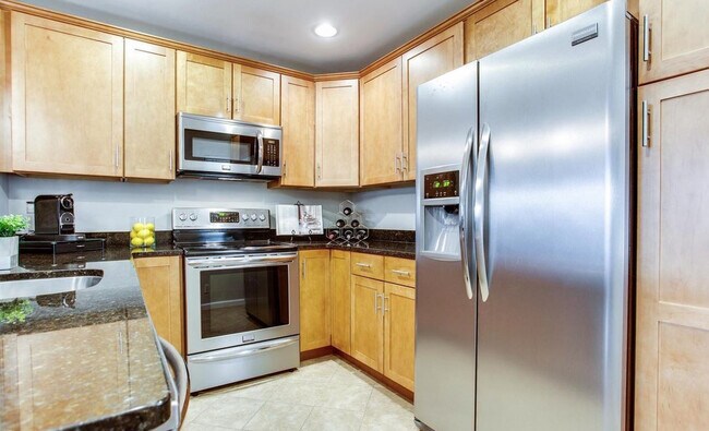 Cocina con electrodomésticos de acero inoxidable y gabinetes con cierre suave. - 2681 Glengyle Dr