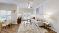 Located at 1900 Walnut St in Bastrop, Texas, this thoughtfully designed 2-bedroom, 2-bathroom residence offers a comfortable and stylish single-floor layout. The open-concept living and dining area serves as the heart of the home, featuring warm hardwood-style flooring, crown molding, and a ceiling fan that enhances air circulation throughout. Natural light pours in through multiple windows and a set of French doors, creating a bright and welcoming ambiance. The kitchen is well-equipped with rich cherry-toned cabinetry, granite-style countertops, white appliances, a tile backsplash, and a breakfast bar that connects seamlessly to the living space. The spacious primary bedroom includes a ceiling fan, large windows with outdoor views, and access to a generous walk-in closet fitted with wire shelving and ample storage. Both bathrooms are clean and functional, with one featuring a soaking tub, wide vanity with white cabinetry, and hardwood-style flooring. The second bedroom is bright and comfortably sized. A connecting hallway links all rooms efficiently. Throughout the residence, neutral tones and consistent flooring create a cohesive, inviting atmosphere well-suited for everyday living.