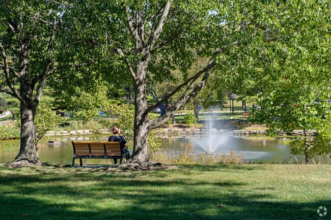 A resident of St. Ann relaxes on a park bench beside the pond in Tiemeyer Park.
