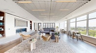 Located at 1 Gibson Way in Revere, MA, this elegantly designed single-floor space offers an expansive, open layout with refined modern finishes throughout. The living room is a standout centerpiece, featuring a distinctive slatted ceiling with integrated lighting, wide-plank hardwood floors, and floor-to-ceiling windows that flood the interior with natural light. A sleek built-in fireplace with flanking shelving adds warmth and architectural interest, while panoramic views of the surrounding waterfront and greenery create a stunning backdrop.

The kitchen is equally impressive, showcasing parquet-style flooring, flat-front cabinetry in light wood tones, contrasting dark lower cabinets, and a large waterfall-edge island with bar seating. Statement brass pendant hood fixtures and large-format windows with waterfront views elevate the culinary space to a design focal point.

The balcony extends the living experience outdoors, offering a generously sized deck with wood and tile finishes, high-top communal seating, and sweeping open views of the horizon—enhanced by string lighting overhead for evening ambiance.

Throughout the space, a cohesive palette of warm neutrals, natural wood, and soft whites creates a calm, contemporary atmosphere that is both functional and visually inviting.