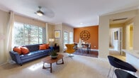 Located at 9874 E Arizona Dr in Aurora, Colorado, this single-floor residence offers a well-designed layout with a cohesive mid-century modern aesthetic throughout. The open-concept living and dining area serves as the heart of the home, where plush carpeting and a ceiling fan complement the comfortable living space. A fireplace with a raised mantle anchors the living room, which is bathed in natural light from large windows overlooking lush greenery. A sliding glass door provides direct access to a private outdoor balcony. The dining area is distinguished by a bold terracotta accent wall and built-in shelving, adding both color and functional storage to the space. The kitchen features dark espresso cabinetry, light stone countertops, a breakfast bar, and stainless steel appliances, including a full-size refrigerator. Wood-look flooring runs through the kitchen and dining areas, contrasting beautifully with the carpeted living spaces. The primary bedroom includes a dramatic dark accent wall, a spacious walk-in closet, and a second bedroom offers direct balcony access through a sliding glass door. The bathroom is equipped with a full tub-shower combination, wood-look flooring, and a vanity with ample counter space. Crown molding throughout adds a refined finishing touch.