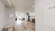 Located in the Rosenthal neighbourhood of Edmonton, Alberta, this thoughtfully designed single-floor home offers a well-appointed layout encompassing one bedroom, two bathrooms, a kitchen, a living room, a dedicated office, and a walk-in closet. Throughout the home, light-toned engineered hardwood flooring creates a warm, cohesive foundation that complements the crisp white walls and modern aesthetic.

The kitchen is a standout feature, outfitted with two-tone cabinetry — white upper cabinets paired with wood-grain lower cabinets — white quartz countertops, a subway tile backsplash, and a full suite of stainless steel appliances including a refrigerator, range, over-the-range microwave, and dishwasher.

The spacious primary bedroom receives natural light through a large window with neighbourhood views and includes a generously sized walk-in closet fitted with multi-tier wire shelving and hanging rods. Both bathrooms are finished with elegant marble-look tile flooring and dark wood vanities with white countertops. The primary ensuite features a glass-enclosed shower, while the second bathroom is designed for accessibility, complete with grab bars and a roll-in shower.

The bright office space includes a window overlooking the backyard, providing a comfortable and functional work area. The living room features recessed lighting and sliding glass patio doors that open to a private outdoor space with a backyard view.