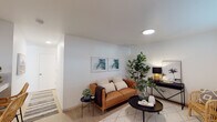 Located at 6689 El Colegio Rd in Goleta, California, this single-floor unit offers a thoughtfully designed layout with clean, contemporary finishes throughout. Light-toned luxury vinyl plank flooring runs continuously across the space, complementing the bright white walls and smooth ceilings fitted with recessed round lighting fixtures.

The living area is open and welcoming, providing ample room for comfortable seating arrangements. Framed botanical artwork adorns the walls, adding a touch of natural color to the neutral palette.

The kitchen is efficiently laid out in a U-shape configuration, featuring flat-panel cabinetry in a light wood tone, white quartz countertops, an undermount stainless steel sink, and a full suite of white appliances including a refrigerator, range, and microwave. A peninsula counter with bar seating extends the functional workspace and serves as a casual dining area.

The bedrooms are bright and well-proportioned, each benefiting from natural light through slatted blinds. Sliding mirrored closet doors add depth and storage in multiple rooms, while built-in cabinetry provides additional organization. The bathroom features a dual-sink vanity with light gray cabinetry, quartz countertops, a wide mirror, and a bright overhead light bar, all finished with the same cohesive, modern aesthetic found throughout the unit.