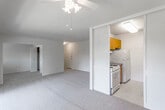 This single-floor residence offers a thoughtfully laid-out living space across several well-defined areas. The generously sized living room serves as the heart of the unit, featuring neutral-toned wall-to-wall carpeting, a ceiling fan with light fixture, and expansive sliding glass doors that open to a private balcony with outdoor views. An adjacent windowed nook extends the living area, filling the space with natural light.

The galley-style kitchen is efficiently designed with warm wood cabinetry above and below dark speckled countertops lining both sides. White appliances, including a gas range, refrigerator, and dishwasher, are neatly integrated, with tile flooring completing the space. A louvered sliding door separates the kitchen from the living area.

The bedroom offers comfortable proportions with soft carpeting, a wide window overlooking greenery, and a sliding-door closet providing ample storage. A second carpeted room offers additional flexible living space.

The bathroom features tile flooring, a full soaking tub with tiled shower surround, a wood-framed vanity mirror, and a single-sink vanity with white countertop, providing a clean and functional design throughout.
