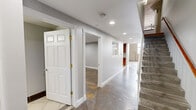 Located at 1429 Park St in Hartford, CT, this two-floor loft-style space showcases a compelling mix of industrial architecture and contemporary design. Polished concrete floors run throughout the main level, complementing soaring ceilings, exposed brick, raw concrete columns, and visible ductwork that give the space a distinctive urban character. Large windows flood the living area with natural light, highlighting the open, airy layout.

The kitchen is well-appointed with rich wood cabinetry, granite countertops, stainless steel appliances, and classic tile flooring. A pass-through window connects the kitchen to the living area, enhancing the open-concept feel. The living room benefits from the dramatic ceiling height and exposed structural elements that reinforce the loft aesthetic.

Both bathrooms feature modern vessel sinks with glass vanities, offering a sleek contrast to the building's raw industrial bones. One bathroom showcases warm hardwood flooring alongside large-format tile and an exposed concrete column, creating a striking visual blend of textures. A dedicated walk-in closet with wire shelving provides practical storage. The hallway connects the levels cleanly, with a staircase leading to the upper floor, which offers additional living space with warm hardwood flooring throughout.