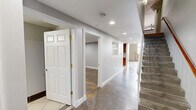 Located at 1429 Park St in Hartford, CT, this two-floor loft-style space showcases a compelling mix of industrial architecture and contemporary design. Polished concrete floors run throughout the main level, complementing soaring ceilings, exposed brick, raw concrete columns, and visible ductwork that give the space a distinctive urban character. Large windows flood the living area with natural light, highlighting the open, airy layout.

The kitchen is well-appointed with rich wood cabinetry, granite countertops, stainless steel appliances, and classic tile flooring. A pass-through window connects the kitchen to the living area, enhancing the open-concept feel. The living room benefits from the dramatic ceiling height and exposed structural elements that reinforce the loft aesthetic.

Both bathrooms feature modern vessel sinks with glass vanities, offering a sleek contrast to the building's raw industrial bones. One bathroom showcases warm hardwood flooring alongside large-format tile and an exposed concrete column, creating a striking visual blend of textures. A dedicated walk-in closet with wire shelving provides practical storage. The hallway connects the levels cleanly, with a staircase leading to the upper floor, which offers additional living space with warm hardwood flooring throughout.