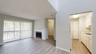 Located at 7932 Southside Blvd in Jacksonville, Florida, this single-story residence offers a thoughtfully designed layout with a consistent, neutral aesthetic throughout. The main living area is an open, airy space highlighted by a wood-surround fireplace and floor-to-ceiling vertical blinds that allow generous natural light to filter in, creating a bright and welcoming atmosphere. The flooring throughout the residence features durable wood-look planks in warm, neutral tones that tie each room together seamlessly. The dining area benefits from an elevated ceiling detail and a pendant light fixture, adding a touch of architectural character. The galley-style kitchen is efficiently arranged with ample white cabinetry, light countertops, a stainless steel sink, and a full suite of white appliances, including an electric range. The bedrooms are comfortably sized, each featuring windows with natural light, textured ceilings, and the same wood-look flooring found throughout the home. The bathroom is clean and functional, offering a vanity with light countertops, a tub-shower combination, and coordinating finishes. Textured walls and ceilings are present throughout, lending a consistent finish to the interior. The overall ambiance is clean, move-in ready, and well-maintained.