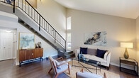 Located at 901 St Johns Wood Dr in Richmond, VA, this two-story home offers a comfortable and functional layout across two floors. The main level sets a welcoming tone with its dramatic vaulted ceilings in the living room, which is bathed in natural light through a large sliding glass door that frames outdoor greenery. Hardwood-style flooring flows throughout the main level, complementing the neutral, contemporary color palette. A dedicated dining area with a ceiling fan sits adjacent to the living room, offering a bright and airy space for gatherings. The galley-style kitchen features white cabinetry, dark countertops, stainless steel appliances including a gas range and refrigerator, and the added convenience of in-unit laundry. The main level also includes a separate dining room and hallway. Upstairs, the spacious primary bedroom is a serene retreat with plush carpeting and a window overlooking tree-lined surroundings. The additional bedrooms are well-sized, each with carpet flooring and multiple windows that invite abundant natural light. Two full bathrooms, each with a tub-shower combination and clean white finishes, serve the home. The overall ambiance is modern, clean, and move-in ready.