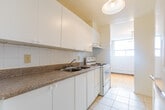 Located at 2440 Hurontario Street in Mississauga, this 2-bedroom, 1-bathroom unit offers a functional and well-organized single-floor layout. A tiled entryway hallway leads into the main living areas, providing a clean transition throughout the space.

The galley-style kitchen is efficiently designed with white cabinetry extending to the ceiling, granite-style countertops along both sides, a tiled backsplash, and light tile flooring. A full-size refrigerator is included, and the layout maximizes counter and storage space.

Both bedrooms feature warm parquet wood flooring in a classic basket-weave pattern, neutral white walls, and baseboard heating. The primary bedroom is a comfortable size, includes a large double-door closet, and benefits from a window that brings in natural light. The second bedroom is equally practical, also with parquet flooring and baseboard heating.

The bathroom includes a full soaker tub with an overhead shower, finished with neutral ceramic wall tiles for a clean, timeless look.

Throughout the unit, the consistent use of light, neutral tones and the warm wood parquet flooring create a cohesive and inviting atmosphere. The straightforward layout and practical finishes make this a well-suited space for everyday living in a central Mississauga location.
