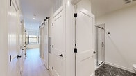 Located at 65 Jolley Dr in Bloomfield, Connecticut, this thoughtfully designed single-floor residence combines contemporary aesthetics with functional living. The open layout is anchored by light hardwood flooring that flows seamlessly throughout the main living areas, creating a bright and cohesive atmosphere.

The kitchen is a standout feature, outfitted with flat-panel light wood cabinetry extending to the ceiling for ample storage, a full suite of stainless steel appliances including a range, microwave, refrigerator, and dishwasher, and a crisp white quartz countertop. A subway tile backsplash and matte black hardware add refined contrast, while a large window frames an outdoor view and fills the space with natural light.

The hallway showcases distinctive two-panel white barn-style doors accented with matte black hardware and ceiling-mounted sliding barn door tracks, contributing a modern yet classic design element. Recessed lighting throughout maintains a clean, uncluttered ceiling line.

The bathroom features bold dark marble-style tile flooring with dramatic veining, a glass-enclosed shower with a sleek sliding door, and crisp white walls that keep the space feeling fresh and polished. The bedroom offers plush carpeting and clean white walls, providing a calm, neutral retreat. This residence delivers a well-appointed, move-in-ready living experience with upscale finishes at every turn.