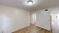Located at 1993 Water St in Morgantown, WV, this single-floor, two-bedroom, one-bathroom unit offers a practical and well-organized layout. Throughout the space, warm wood-look flooring runs continuously, complemented by clean, neutral-toned walls and white trim that create a bright and cohesive interior atmosphere.

The unit features two living areas, providing flexibility for both lounging and dining or home office use. Each room is finished with flush-mount ceiling lighting, textured ceilings, and ample electrical outlets. The two bedrooms are well-proportioned, with the primary bedroom offering a generous footprint, dedicated closet access, and a sliding glass door leading to an outdoor balcony area. The second bedroom includes a window that allows natural light to filter in.

The kitchen is equipped with standard appliances, including a range and sink, and is efficiently positioned within the floor plan. A full bathroom serves the unit, and both bedrooms benefit from their own dedicated closet spaces. The entry area features a full-panel white door alongside a window, welcoming residents into the space. Overall, this unit delivers a clean, move-in ready interior with consistent finishes and a straightforward, functional layout suited for everyday living in Morgantown.