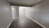 Located at 8128 Barclay St in Dallas, TX, this one-bedroom, one-bathroom unit offers a practical and efficient single-floor layout. The living room serves as the welcoming centerpiece of the space, featuring durable wood-look flooring, a painted white brick accent wall that adds texture and character, and a textured ceiling. Natural light filters in through a window near the entry door, lending the room a bright, open feel despite its compact footprint.

The galley-style kitchen is thoughtfully designed with ample white upper and lower cabinetry, a gray laminate countertop, a single-basin sink, and white appliances, including a range. The light wood-look flooring continues here, maintaining a cohesive aesthetic throughout.

The bedroom provides a quiet retreat, finished with the same light-toned flooring and neutral wall tones that keep the space feeling clean and airy.

The bathroom features full-height ceramic tile surrounding the tub-shower combination, offering a classic and easy-to-maintain finish. A standard toilet and clean white fixtures complete the space.

Throughout the unit, neutral gray tones, consistent flooring, and white trim create a unified, move-in-ready aesthetic well-suited for those seeking a functional home in Dallas.