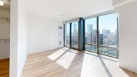 Located in Chicago's vibrant River North neighborhood, this efficiently designed unit at 520 N Kingsbury Street offers a thoughtful layout across a single floor. The combined kitchen and living area forms the heart of the space, where light hardwood flooring and crisp white walls create a clean, contemporary aesthetic. Floor-to-ceiling windows in the living area flood the room with natural light and frame sweeping views of the Chicago skyline, adding a dramatic sense of openness.

The kitchen is well-appointed with flat-front wood cabinetry, a subway tile backsplash, light stone countertops, and a full suite of stainless steel appliances, including a refrigerator, gas range, and built-in microwave. A single-basin sink with a modern arc faucet completes the functional workspace.

The unit includes two bathrooms. One features neutral stone-tiled flooring, a wood-toned vanity with a mirror, and accessibility-friendly grab bars. The second bathroom offers a soaking tub with elegant elongated white tile surround and chrome fixtures. A dedicated closet provides practical storage. Light-filled corridors connect each space, maintaining the unit's bright and airy character throughout.
