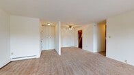 Located at 7825 S Scepter Dr in Franklin, WI, this single-floor unit offers a practical and comfortable layout designed for everyday living. The open living area is generously sized, finished with neutral-toned wall-to-wall carpeting that extends throughout the main living spaces and bedrooms. A ceiling fan with light fixture anchors the central living zone, while baseboard heating runs along the perimeter walls, ensuring consistent warmth throughout the unit. Large white panel closets near the entryway provide convenient storage upon arrival.

The kitchen is a functional highlight, featuring warm oak cabinetry with abundant upper and lower storage, dark granite-style countertops, and durable hardwood-style flooring. Stainless steel appliances include a gas range, dishwasher, and refrigerator, making it well-suited for daily cooking.

The bedrooms are carpeted and quietly appointed, with one room featuring a walk-in closet equipped with built-in shelving and hanging rods. A window with blinds allows natural light to filter in. The full bathroom includes a tub-shower combination with tile surround, oak vanity cabinetry, and hardwood-style flooring, while a second bathroom offers a vanity with mirror cabinet. The floor plan also reveals access to an outdoor balcony, adding a welcome extension of living space.