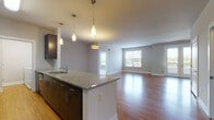 Located at 23220 Chagrin Blvd in Beachwood, Ohio, this single-floor residence offers a thoughtfully designed open-concept layout that seamlessly connects the kitchen, dining, and living areas. The kitchen serves as a central focal point, featuring a large island with granite countertops, an undermount sink, pendant lighting, dark espresso cabinetry, a tile backsplash, and black appliances including a refrigerator, range, and microwave. Rich hardwood flooring extends throughout the main living areas, reflecting natural light that pours in through generously sized windows.

The spacious living area provides an open, airy feel with neutral-toned walls and clean architectural lines. The bedrooms are carpeted for comfort and brightness, each offering large windows with outdoor views of the surrounding Beachwood neighborhood. The bathrooms are finished with large-format tile flooring, dark wood vanities topped with granite countertops, and framed mirrors. The primary bathroom includes a walk-in shower and direct access to a walk-in closet with built-in shelving.

A dedicated in-unit laundry room houses a full-size washer and dryer with overhead shelving, adding everyday convenience. A half bath with tile flooring and chrome fixtures rounds out this well-appointed residence.