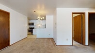 Located at 1248 N 68th St in Wauwatosa, Wisconsin, this single-floor unit offers a practical and well-maintained layout with updated finishes throughout. The kitchen serves as a central highlight, featuring white shaker-style cabinetry, granite-look countertops, and a full suite of stainless steel appliances including a refrigerator with an in-door ice and water dispenser, an electric range, built-in microwave, and dishwasher. Light tile flooring runs through the kitchen, which connects to the living area via a half-wall peninsula. A chandelier fixture overhead adds a touch of warmth to the space.

The living area is generously proportioned, finished with neutral carpet and white walls that create a clean, open feel. A large picture window allows natural light to fill the room while offering views of the surrounding landscape. Additional carpeted rooms provide flexible space, with windows fitted with blinds for light control and baseboard heating units along the walls.

The bathrooms are neatly appointed, one featuring a modern floating vanity with a contemporary faucet and framed mirror over tile flooring, while the second includes a full tub-shower combination with a matching vanity. The overall ambiance is clean, neutral, and move-in ready.