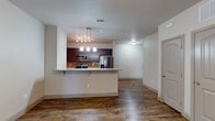 This single-floor residence offers a thoughtfully designed layout that balances open communal spaces with comfortable private areas. The open-concept kitchen and living area serves as the heart of the home, anchored by a peninsula with granite countertops that provides both additional workspace and casual seating. Rich, dark cabinetry pairs with a subway tile backsplash and a full suite of stainless steel appliances, including a range, over-the-range microwave, and French door refrigerator. A pendant light fixture above the peninsula adds a polished finishing touch. Warm, wood-style plank flooring extends throughout the main living areas, complementing the neutral wall tones and clean white trim.

The living areas are generously proportioned, each equipped with ceiling fans and easy access to the bedrooms and bathrooms. Bedrooms feature plush carpeting and natural light from windows with blinds. Each bathroom is outfitted with a dark wood vanity topped with granite counters, an undermount sink, a large mirror, and a tub-shower combination. Arched interior doors carry a consistent design detail throughout, contributing to the cohesive, modern-traditional aesthetic of the space.