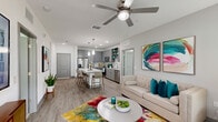 Located in Orlando, FL, this thoughtfully designed 2-bedroom, 3-bathroom residence offers a cohesive modern aesthetic across a well-utilized single floor. The open-concept kitchen and living area serves as the heart of the home, where gray shaker cabinetry, granite countertops, a herringbone tile backsplash, and a full suite of stainless steel appliances create a polished, functional cooking space. A large central kitchen island with pendant lighting provides generous seating and doubles as a gathering point. The adjacent living room features wood-look flooring, a ceiling fan, and large windows with balcony access, filling the space with natural light and offering outdoor enjoyment. Both bedrooms are carpeted and feature windows that invite natural light, with the primary bedroom offering a generous footprint, a dedicated closet, and direct access to its own en-suite bathroom. Each of the three bathrooms is finished with striking marble-look porcelain tile floors and surround, gray vanities with granite countertops, and soaking tub-shower combinations. Two closets provide ample storage throughout. The overall ambiance is bright, clean, and contemporary, with consistent finishes that lend a cohesive and refined character to every room.