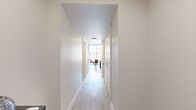 Located at 505 Church Street in the heart of downtown Nashville, this one-bedroom, one-bathroom unit offers an efficient and thoughtfully designed layout. The space is defined by striking architectural details, including an exposed concrete ceiling that adds an industrial character balanced by crisp white walls and light wood-style flooring throughout.

A bright, open living and kitchen area anchors the unit, where floor-to-ceiling windows flood the space with natural light and frame sweeping views of the Nashville skyline. The kitchen features stainless steel appliances — including a gas range, microwave, refrigerator, and dishwasher — paired with white upper cabinetry, wood-toned lower cabinets, and a classic subway tile backsplash.

The generously sized primary bedroom comfortably accommodates a full living area alongside the sleeping space, with a ceiling fan and continued exposure to natural light. A clean, light-filled hallway connects the entrance to the main living areas, providing a seamless flow through the unit.

The bathroom is finished with large-format neutral tiles and features a walk-in glass shower with chrome fixtures and an LED-backlit mirror, offering a sleek, modern aesthetic. The entrance provides a functional transition into the home. Overall, the unit delivers a polished urban living experience in one of Nashville's most vibrant neighborhoods.