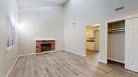 Located at 1301 SW Harrison St in Topeka, Kansas, this well-appointed one-bedroom, one-bathroom residence offers a thoughtfully organized single-floor layout. The living room immediately impresses with its dramatic vaulted ceilings that create a generous sense of openness and volume, complemented by a classic brick wood-burning fireplace that serves as a striking focal point. Light-toned luxury vinyl plank flooring runs throughout the space, lending a clean, cohesive feel to each room. Natural light filters in through windows fitted with blinds, brightening the neutral, soft-gray walls.

The kitchen is efficiently designed with white cabinetry extending to the ceiling for ample storage, a full suite of white appliances including a refrigerator, range, and dishwasher, and a countertop with an integrated sink. The bedroom offers a comfortable, well-proportioned retreat with its own window for natural light, a textured ceiling, and direct access to a dedicated walk-in closet with built-in shelving. A pendant light fixture adds a subtle decorative touch. The bathroom features a full-size soaking tub and shower combination with clean white surround panels and chrome fixtures. A separate closet provides additional storage for the unit.