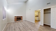 Located at 1301 SW Harrison St in Topeka, Kansas, this well-appointed one-bedroom, one-bathroom residence offers a thoughtfully organized single-floor layout. The living room immediately impresses with its dramatic vaulted ceilings that create a generous sense of openness and volume, complemented by a classic brick wood-burning fireplace that serves as a striking focal point. Light-toned luxury vinyl plank flooring runs throughout the space, lending a clean, cohesive feel to each room. Natural light filters in through windows fitted with blinds, brightening the neutral, soft-gray walls.

The kitchen is efficiently designed with white cabinetry extending to the ceiling for ample storage, a full suite of white appliances including a refrigerator, range, and dishwasher, and a countertop with an integrated sink. The bedroom offers a comfortable, well-proportioned retreat with its own window for natural light, a textured ceiling, and direct access to a dedicated walk-in closet with built-in shelving. A pendant light fixture adds a subtle decorative touch. The bathroom features a full-size soaking tub and shower combination with clean white surround panels and chrome fixtures. A separate closet provides additional storage for the unit.