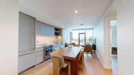 Located at 3401 S La Cienega Blvd in Los Angeles, this thoughtfully designed one-bedroom, one-bathroom residence offers a cohesive blend of modern aesthetics and functional living across a single floor. The layout encompasses a living room, kitchen, bedroom, hallway, bathroom, and closet.

The living room is a bright, welcoming space anchored by floor-to-ceiling windows and a glass door that opens directly to a private balcony, framing sweeping views of the Los Angeles cityscape and surrounding hillsides. Warm hardwood flooring runs throughout, complementing the light-toned walls and creating an airy ambiance.

The kitchen is a standout feature, outfitted with custom matte blue cabinetry trimmed in brass-toned hardware, under-cabinet lighting, and a clean white countertop. A full-size range and ample storage make this a highly functional cooking space that also serves as an elegant backdrop for the adjacent dining area.

The bedroom is generously proportioned, offering its own access to the balcony through expansive windows that flood the room with natural light and provide the same impressive hillside views. The space is calm and restful in character.

The bathroom is finished with a distinctive checkerboard tile pattern across the floors and shower walls, a glass-enclosed walk-in shower, a warm wood vanity, and an illuminated mirror — delivering a spa-like atmosphere with refined, contemporary detail.