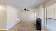 Located in El Paso, TX, this efficient single-floor residence offers 1 bedroom and 2 bathrooms within a well-organized layout. The living room serves as the centerpiece of the home, featuring a striking black-tiled fireplace flanked by multiple windows that fill the space with natural light. A ceiling fan with light fixture adds both comfort and function, while plush carpeting underfoot creates a warm, inviting atmosphere. The textured ceiling carries throughout the common areas.

The kitchen is designed for practicality, featuring warm wood cabinetry, black appliances including a range and refrigerator, and a granite-style countertop with a peninsula breakfast bar that opens to the dining area. A dedicated laundry area with a stacked washer and dryer unit is conveniently accessible just off the kitchen.

The bedroom is a comfortable retreat with carpet flooring, a window allowing natural light, and a closet offering organized storage. Two closets are present throughout the unit for ample storage needs.

Both bathrooms are functional and clean; one features wood-look tile flooring, a full bathtub with white subway tile surround, and standard fixtures. Hallways connect each area of the home efficiently, completing this well-appointed single-level residence.