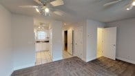 Located at 1 Presidio Pointe Pl in Cross Lanes, West Virginia, this two-floor property offers a practical and well-organized layout throughout both levels. The main living area is generously sized, featuring plush carpeted flooring and a ceiling fan with integrated lighting that provides comfortable airflow and illumination. A sliding glass door with vertical blinds allows natural light to flow in while offering access to the outdoors. The kitchen is efficiently designed with white cabinetry, dark countertops, a double-basin sink, and white appliances including a range, built-in microwave, and refrigerator. Light tile flooring runs through the kitchen and connects seamlessly to the entryway. Two bathrooms serve the residence — one featuring a tub-shower combo with tile flooring, and another with a vanity featuring dark countertops, a mirror with overhead lighting, and a tub. The carpeted bedrooms are bright and well-proportioned, each equipped with ceiling fans and windows that bring in natural light. The attached garage offers ample space for vehicle storage and features an automatic door opener and a textured ceiling. Throughout the home, neutral wall tones and clean finishes create a bright, move-in-ready atmosphere.