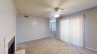 This single-floor, one-bedroom, one-bathroom unit offers a well-organized layout making efficient use of its compact footprint. The living area is carpeted throughout and features a ceiling fan with integrated lighting, a textured ceiling, and a full-width vertical blind treatment that provides light control and privacy. Neutral gray walls and consistent flooring materials create a cohesive, understated aesthetic throughout the space.

The galley-style kitchen is a functional highlight, featuring warm honey-toned cabinetry on both sides, granite-patterned countertops, wood-look hard flooring, a double-basin sink, and white appliances including a coil electric range, overhead microwave, and refrigerator. A hallway leads from the kitchen toward the rest of the unit.

The primary bedroom is a comfortable, carpeted room with a window fitted with horizontal blinds that allow natural light. It includes a dedicated walk-in closet with built-in hanging rods and a separate closet with multiple built-in shelves for added storage flexibility.

The bathroom features wood-look flooring, a full-size soaking tub with white tile surround, and a towel bar. The 3D model also reveals a fireplace in the living area, adding a notable functional feature to the space.