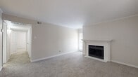 Located at 17630 Wayforest Dr in Houston, TX, this single-story home offers a comfortable and functional layout with two bedrooms and two bathrooms. The living room serves as the heart of the home, featuring soft carpeting, crown molding, and a classic white-mantled fireplace with a black surround that adds warmth and character. Multiple windows invite natural light, creating a bright and welcoming atmosphere throughout.

The galley-style kitchen is efficiently designed with wood-look plank flooring, white cabinetry, a stainless steel refrigerator, and a full suite of appliances including a range and dishwasher — providing everything needed for everyday cooking.

The primary bedroom is a generous retreat, complete with plush carpeting, crown molding, a ceiling fan with light fixture, and a window for natural light. The secondary bedroom also features carpet, crown molding, and a wainscoting-style chair rail detail, adding a refined touch. Both bedrooms offer comfortable proportions suitable for various furniture arrangements.

Both bathrooms are finished with crisp white subway tile surrounds in the tub-shower combinations, wood-look flooring, and marble-topped vanities, delivering a clean and updated aesthetic. A hallway and closet round out the layout, contributing to practical everyday storage and circulation throughout this well-appointed home.