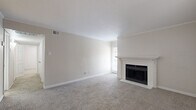 Located at 17630 Wayforest Dr in Houston, TX, this single-story home offers a comfortable and functional layout with two bedrooms and two bathrooms. The living room serves as the heart of the home, featuring soft carpeting, crown molding, and a classic white-mantled fireplace with a black surround that adds warmth and character. Multiple windows invite natural light, creating a bright and welcoming atmosphere throughout.

The galley-style kitchen is efficiently designed with wood-look plank flooring, white cabinetry, a stainless steel refrigerator, and a full suite of appliances including a range and dishwasher — providing everything needed for everyday cooking.

The primary bedroom is a generous retreat, complete with plush carpeting, crown molding, a ceiling fan with light fixture, and a window for natural light. The secondary bedroom also features carpet, crown molding, and a wainscoting-style chair rail detail, adding a refined touch. Both bedrooms offer comfortable proportions suitable for various furniture arrangements.

Both bathrooms are finished with crisp white subway tile surrounds in the tub-shower combinations, wood-look flooring, and marble-topped vanities, delivering a clean and updated aesthetic. A hallway and closet round out the layout, contributing to practical everyday storage and circulation throughout this well-appointed home.