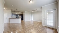 Located at 5525 Mansions Bluffs in San Antonio, TX, this well-designed 2-bedroom, 2-bathroom single-story home offers a comfortable and functional layout. The open-concept living and kitchen area is bright and airy, featuring wood-look flooring throughout, crown molding, and multiple windows fitted with white blinds that allow generous natural light. The kitchen is equipped with dark cabinetry, granite-style countertops, a peninsula island, pendant lighting, and black appliances, including a refrigerator and range. A track lighting system adds additional illumination to the dining and living areas. The primary bedroom is a well-proportioned retreat with sliding glass doors that open directly onto a private patio, offering pleasant outdoor views. It is complemented by a spacious walk-in closet with built-in shelving and hanging rods on multiple walls. The bathrooms feature dark wood vanities with granite-style countertops and tub-shower combinations. The second bedroom also benefits from natural light through a large window. Additional highlights include a dedicated laundry area with hookups and overhead shelving. The patio provides a serene outdoor extension of the living space with open views of the surrounding landscape.
