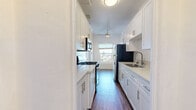 Located on Ivar Avenue in the heart of Hollywood, this 1-bedroom, 2-bathroom residence offers a well-organized single-floor layout with a blend of classic architectural character and practical design. The living room is a highlight of the space, featuring wood-style plank flooring, crown molding, a ceiling fan, and a distinctive arched doorway that adds a charming architectural touch. Large windows with horizontal blinds invite generous natural light and offer views of the surrounding Los Angeles cityscape. A second ceiling fan is present in the spacious primary bedroom, which also benefits from ample natural light and hardwood-style flooring. The kitchen connects conveniently to the living areas, while three hallways provide smooth circulation throughout the unit. The two full bathrooms are finished with clean white tile walls and tub-shower combinations equipped with chrome fixtures and caddy storage. One bathroom features warm-toned ceramic floor tiles, adding a subtle contrast to the otherwise neutral palette. A dedicated closet offers practical storage. A vintage-style cast iron radiator is also present, nodding to the building's heritage. Crown molding and white panel doors complete the refined, classic aesthetic found throughout the home.