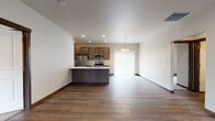 Located at 12007 East Coyote Rock Drive in Spokane Valley, WA, this well-appointed single-floor unit offers a thoughtfully designed open-concept layout that seamlessly connects the living, dining, and kitchen areas. Rich, dark hardwood-style flooring runs throughout the main living spaces, complemented by recessed lighting and neutral-toned walls that create a clean, modern aesthetic.

The kitchen is a standout feature, equipped with a full suite of stainless steel appliances including a refrigerator, electric range, microwave, and dishwasher. Dark wood cabinetry pairs elegantly with crisp white countertops, while a subway tile backsplash adds a contemporary touch. A peninsula with an undermount sink and additional seating space anchors the kitchen and opens directly to the living area. A sliding glass door allows natural light to fill the dining space.

The bedrooms offer plush carpeting and windows with blinds, providing both comfort and privacy. Two full bathrooms serve the unit — one featuring a tub/shower combo with a dark wood vanity, and the other offering a walk-in glass-door shower with matching finishes. Consistent dark wood trim and hardware details tie the design together throughout, giving the entire space a cohesive, polished look.