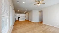 Located at 801 Jacquelyne Dr in Anna, TX, this two-story home offers 3 bedrooms, 4 bathrooms, and a well-considered layout spread across two floors. The main floor forms the heart of the home with an open-concept living room, dining area, and kitchen. The kitchen is a standout feature, showcasing white shaker cabinetry extending to the ceiling, a white subway tile backsplash, stainless steel appliances, and a central island with a quartz countertop and double undermount sink. Light hardwood-style flooring runs throughout the main level, complemented by recessed lighting and a ceiling fan in the living area. A pantry and dedicated laundry room with marble-style tile flooring, built-in shelving, and washer/dryer hookups add functional convenience on this floor. Upstairs, the second floor hosts all three bedrooms, including a generously sized primary bedroom, along with a versatile game room bathed in natural light from multiple windows. The bathrooms are finished with marble-style tile flooring, and the primary bath features a glass-enclosed walk-in shower, a white vanity, and a private water closet. Each bedroom includes a closet, with vaulted ceilings adding character to select rooms. The home maintains a clean, modern aesthetic throughout with neutral tones and bright, airy interiors.