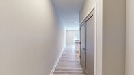 Located at 57 W Merritt Blvd in Fishkill, NY, this thoughtfully designed single-floor residence offers a clean, modern aesthetic with consistent finishes throughout. Light wood-tone flooring flows seamlessly across the living areas and bedrooms, complemented by neutral warm and cool gray wall tones that create a bright, welcoming atmosphere.

The kitchen is a standout feature, showcasing white shaker-style cabinetry, dark quartz countertops, a white subway tile backsplash, and a full suite of stainless steel appliances including a range, over-the-range microwave, dishwasher, and refrigerator. A peninsula with an overhang provides additional seating and defines the open-concept layout, while track lighting and recessed fixtures ensure well-lit workspaces. Multiple windows allow natural light to fill the kitchen and living areas.

The bedrooms are generously proportioned with ample natural light from large windows and light-toned flooring. The bathroom is finished with marble-look tile flooring, a soaking tub with a subway-tiled surround, and a gray vanity with a white countertop. A dedicated laundry room houses a full-size Samsung washer and dryer with overhead shelving. A clean hallway with gray modern doors connects the living spaces, completing this well-appointed, move-in-ready residence.