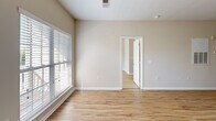 Located at 120 Chamberlain Dr in Asheville, NC, this single-floor, one-bedroom, one-bathroom residence offers a well-organized layout designed for comfortable everyday living. Light wood-style flooring runs consistently throughout the home, creating a cohesive and clean aesthetic in every room.

The combined kitchen and living area forms the heart of the unit. The kitchen is outfitted with warm honey-toned cabinetry, dark granite-style countertops, and a full suite of black appliances including a refrigerator, electric range, microwave, and dishwasher. A peninsula counter extends into the space, providing additional prep area and a natural division between the kitchen and living zone. The living area benefits from a private entrance door with a sidelite window, allowing natural light to filter in.

The spacious primary bedroom features a ceiling fan with light fixture and a sizable window with blinds that brings in natural greenery views from outside. A dedicated closet provides organized storage.

The bathroom is finished with white cabinetry, a wide vanity with a large mirror illuminated by a multi-bulb light bar, and a full soaking tub with shower. The neutral, warm beige tones found throughout the residence contribute to a calm and inviting overall ambiance.