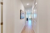 Located at 3305 South Blvd in Charlotte, NC, this 1-bedroom, 1-bathroom residence offers a well-planned layout with modern finishes throughout. Light wood-tone flooring flows seamlessly across the entire space, creating a clean, cohesive aesthetic.

The open-plan kitchen and living room serves as the heart of the home. The kitchen is outfitted with white shaker-style cabinetry, quartz countertops, a subway tile backsplash, stainless steel appliances including a range, microwave, and dishwasher, and an undermount sink. Open shelving adds a contemporary touch. The adjacent living area is bathed in natural light from multiple large windows, offering pleasant views of the surrounding Charlotte skyline.

A bright hallway connects the living area to the private quarters, featuring recessed lighting and wall art display space. The bedroom includes a double-door closet and neutral wall tones, offering a calm retreat. Additional closets throughout the unit provide generous storage. A dedicated laundry area and utility room add everyday convenience.

The bathroom features a white vanity with quartz countertop, a soaking tub with subway tile surround, and a clean, minimalist design. This efficiently designed residence maximizes every square foot with thoughtful, modern touches.