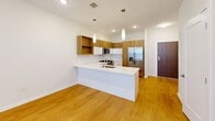 This 620 square foot apartment in Downingtown, PA, offers a thoughtful blend of comfort and functionality. The single-floor layout comprises one bedroom, one bathroom, and an open-concept living area. The kitchen is a standout feature, boasting modern stainless steel appliances, including a side-by-side refrigerator and built-in microwave. White cabinetry contrasts beautifully with warm wood accents, creating a contemporary aesthetic.

The bathroom showcases a clean, minimalist design with a white subway-tiled shower/tub combination and a floating wood vanity. The bedroom, measuring 180 square feet, features plush carpeting and large windows that invite natural light, creating a bright and airy atmosphere.

Throughout the apartment, hardwood flooring in the main living areas adds warmth and durability. The open floor plan enhances the sense of space, making the compact 620 square feet feel larger and more versatile. Recessed lighting and pendant fixtures provide layered illumination, while multiple windows offer views and natural light, contributing to the overall welcoming ambiance of this efficiently designed urban dwelling.